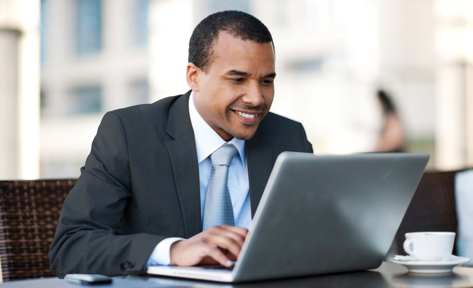 African American male in a business suit on laptop