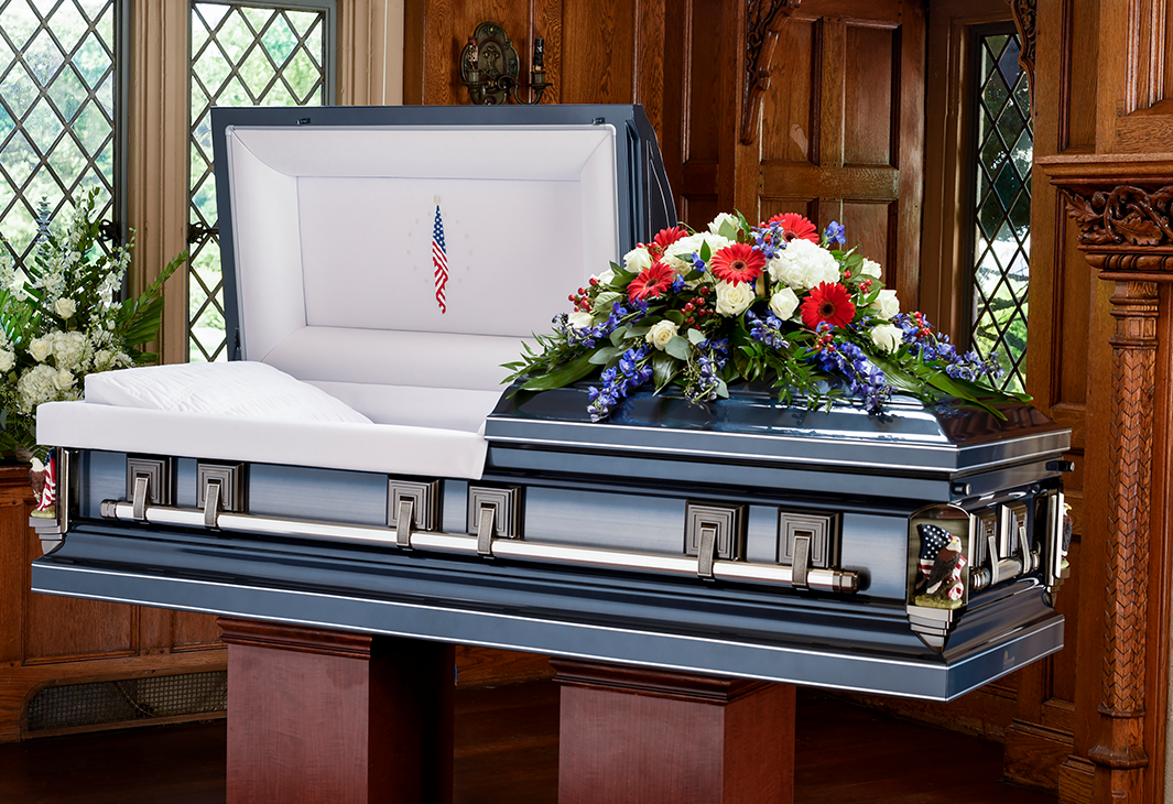 beauty shot of metal blue casket with flower arrangement