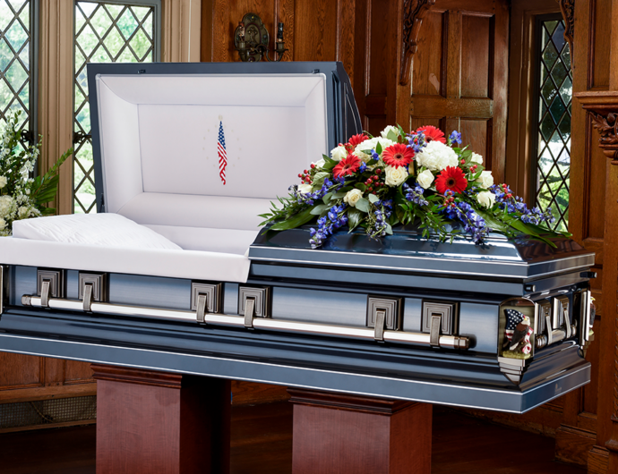 beauty shot of metal blue casket with flower arrangement